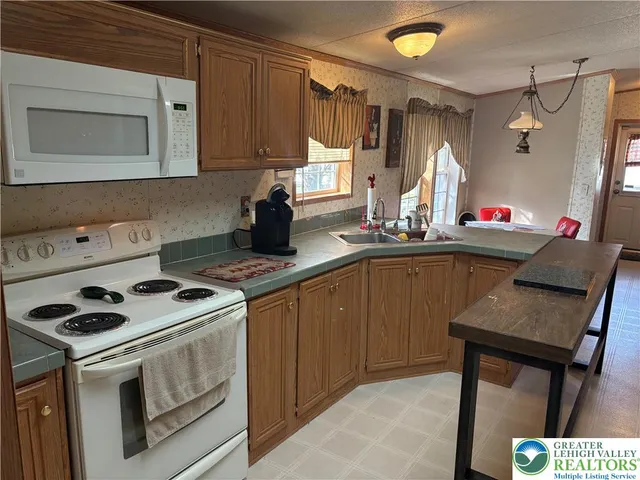 a kitchen with kitchen island a sink stove and refrigerator