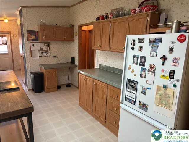 a kitchen with stainless steel appliances a sink a stove a refrigerator and cabinets