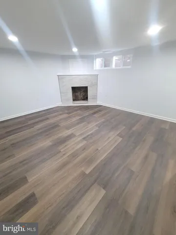 an empty room with wooden floor and fireplace