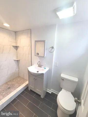 a bathroom with a sink a toilet a mirror and vanity