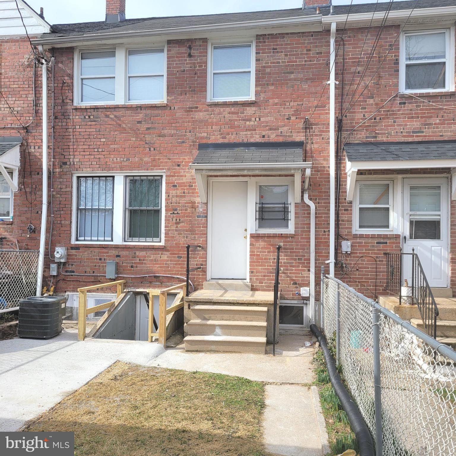 4603 Marble Hall Road Baltimore, MD 21239 - Photo 24 of 24 a view of a brick house with large windows and a bench