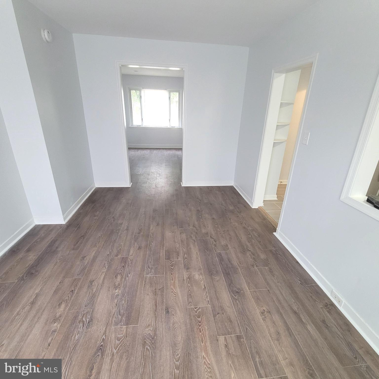 4603 Marble Hall Road Baltimore, MD 21239 - Photo 3 of 24 an empty room with wooden floor and windows