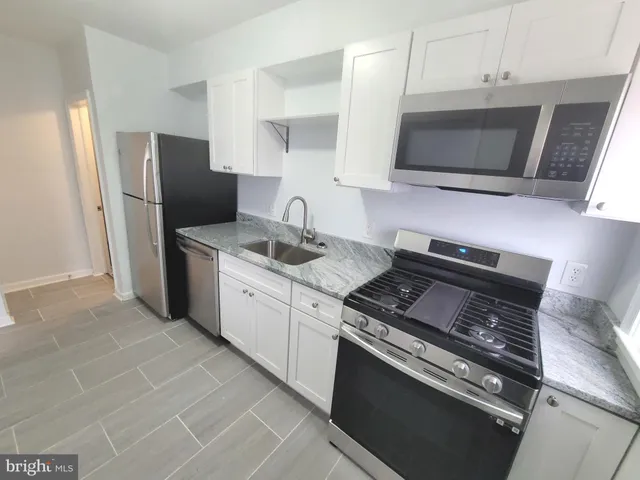 a kitchen with stainless steel appliances a stove a microwave a sink and cabinets