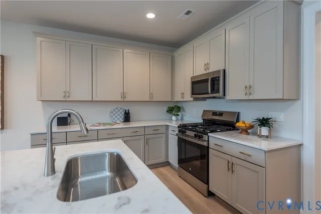 a kitchen with white cabinets sink and white appliances
