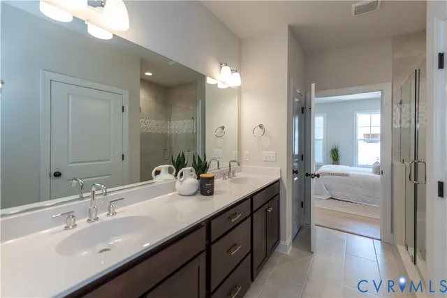 a en suite bathroom with double vanity and a mirror