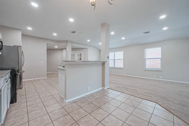a view of a kitchen with center island and stainless steel appliances