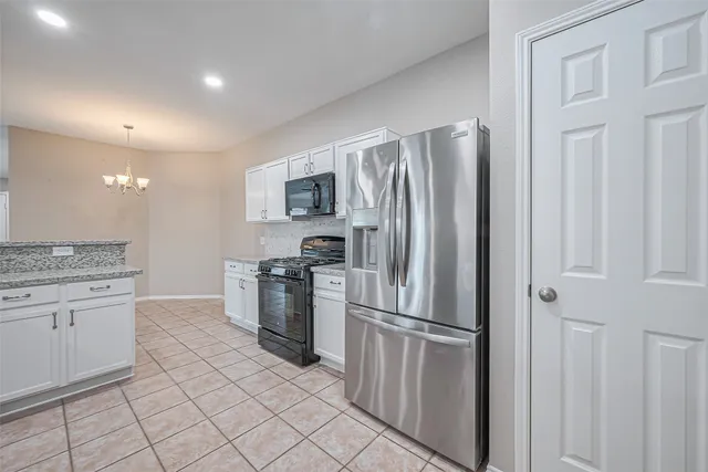 a kitchen with a refrigerator sink and cabinets