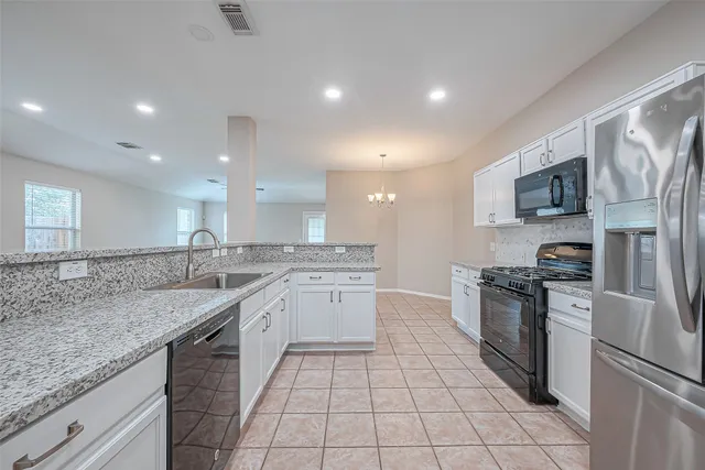 a large kitchen with stainless steel appliances granite countertop a sink stove and refrigerator