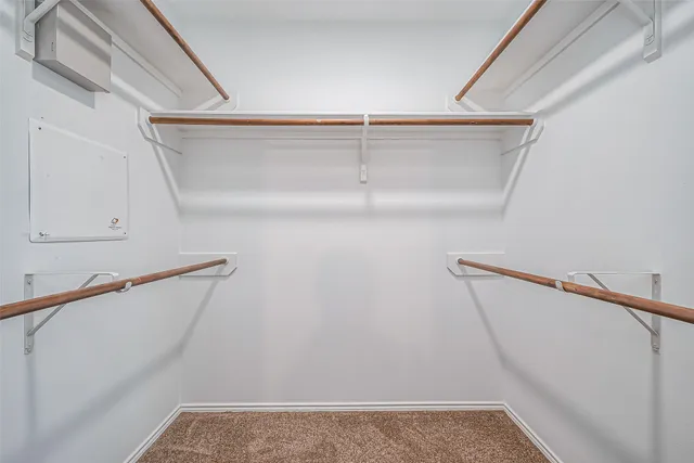 a view of walk in closet with empty racks