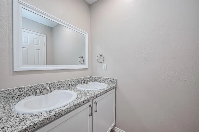 a bathroom with a granite countertop sink and a mirror