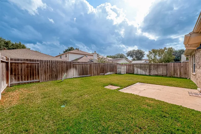 a view of a yard with wooden fence