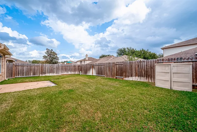 a view of a backyard with wooden fence