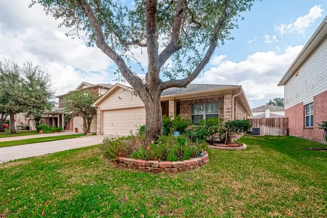 a front view of a house with a yard and trees