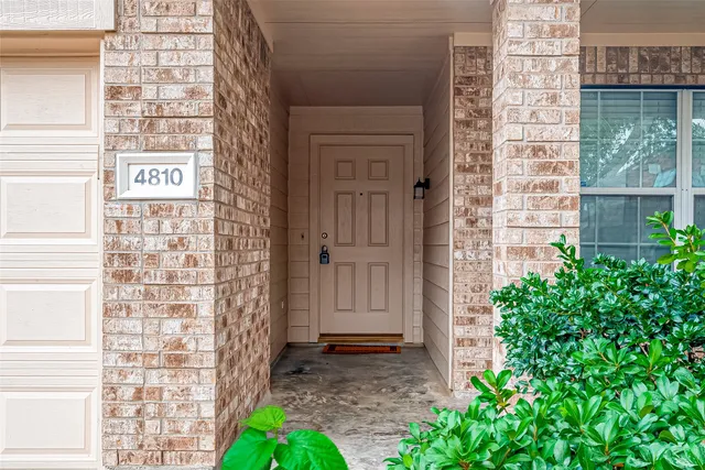 a view of front door of house with potted plants