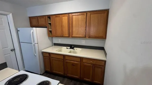 a room with a sink and a refrigerator
