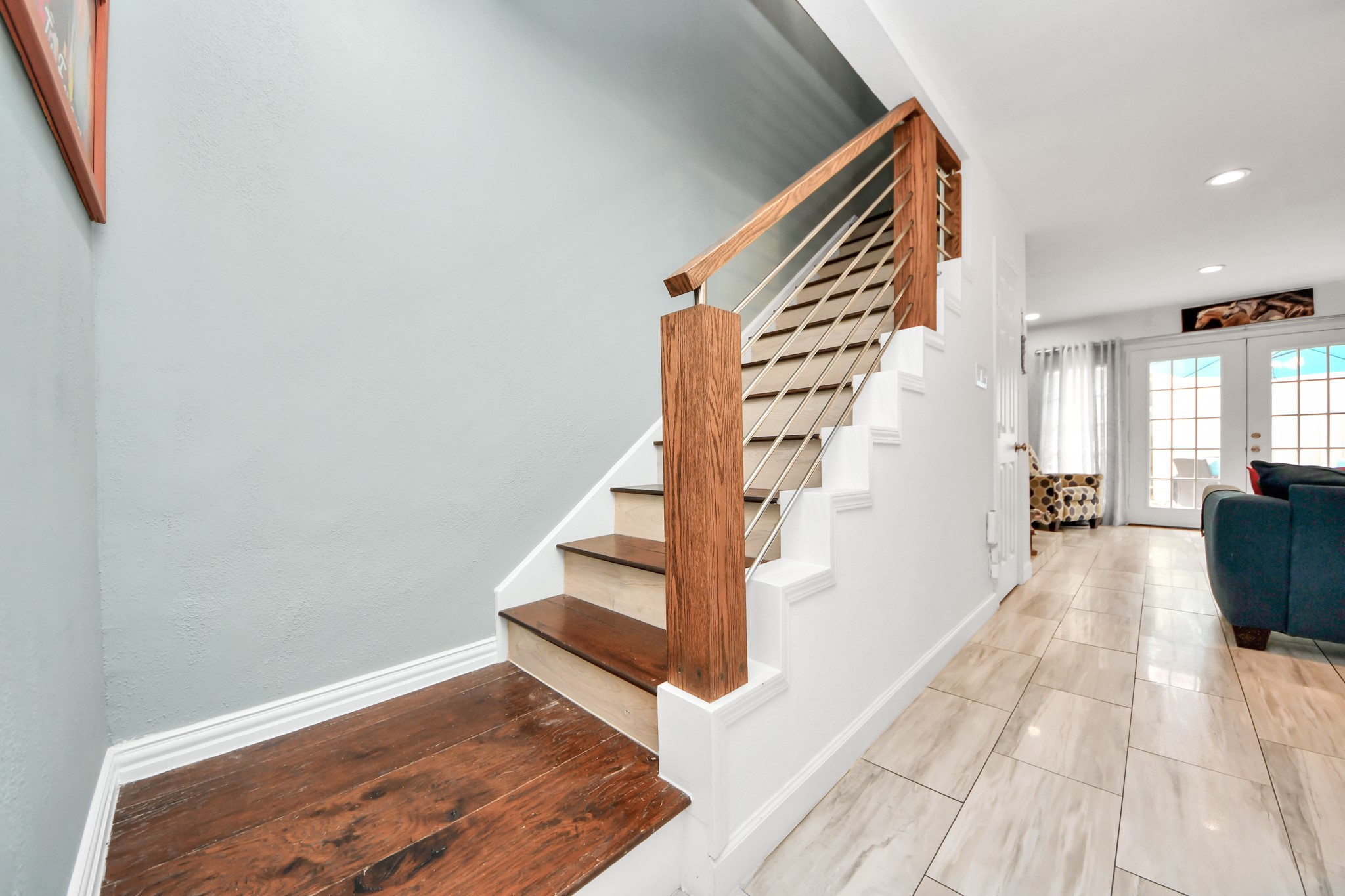 12757 Huntingwick Drive, Unit 142 Houston, TX 77024 - Photo 23 of 36 View from the hallway emphasizing the updated staircase with wood accents.