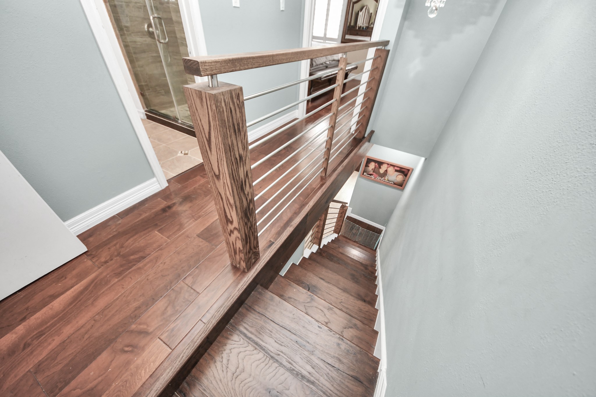12757 Huntingwick Drive, Unit 142 Houston, TX 77024 - Photo 24 of 36 Second-floor perspective featuring the staircase and engineered wood flooring extending throughout the level.