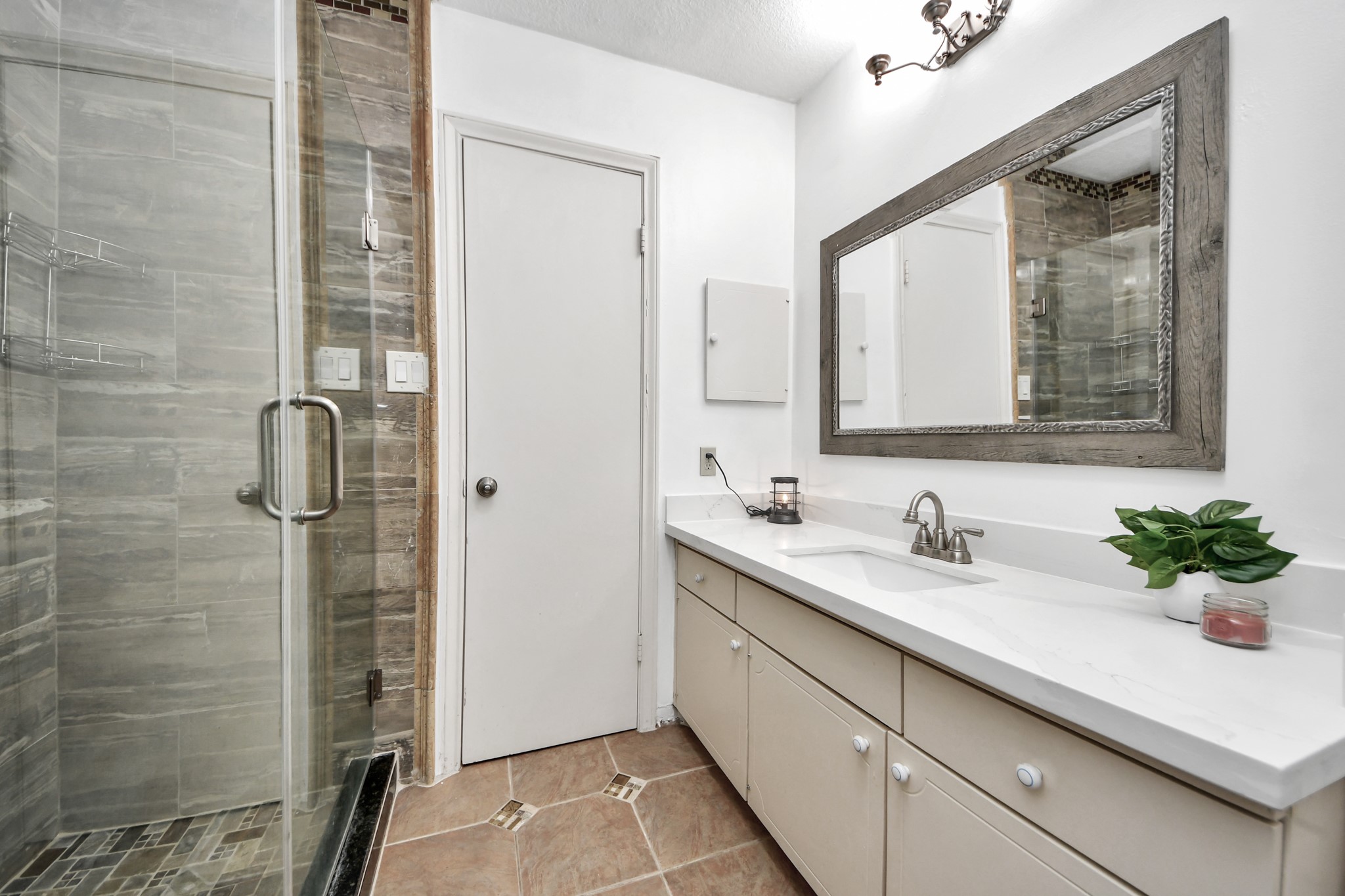 12757 Huntingwick Drive, Unit 142 Houston, TX 77024 - Photo 28 of 36 Updated bathroom featuring a walk-in shower and quartz countertop.