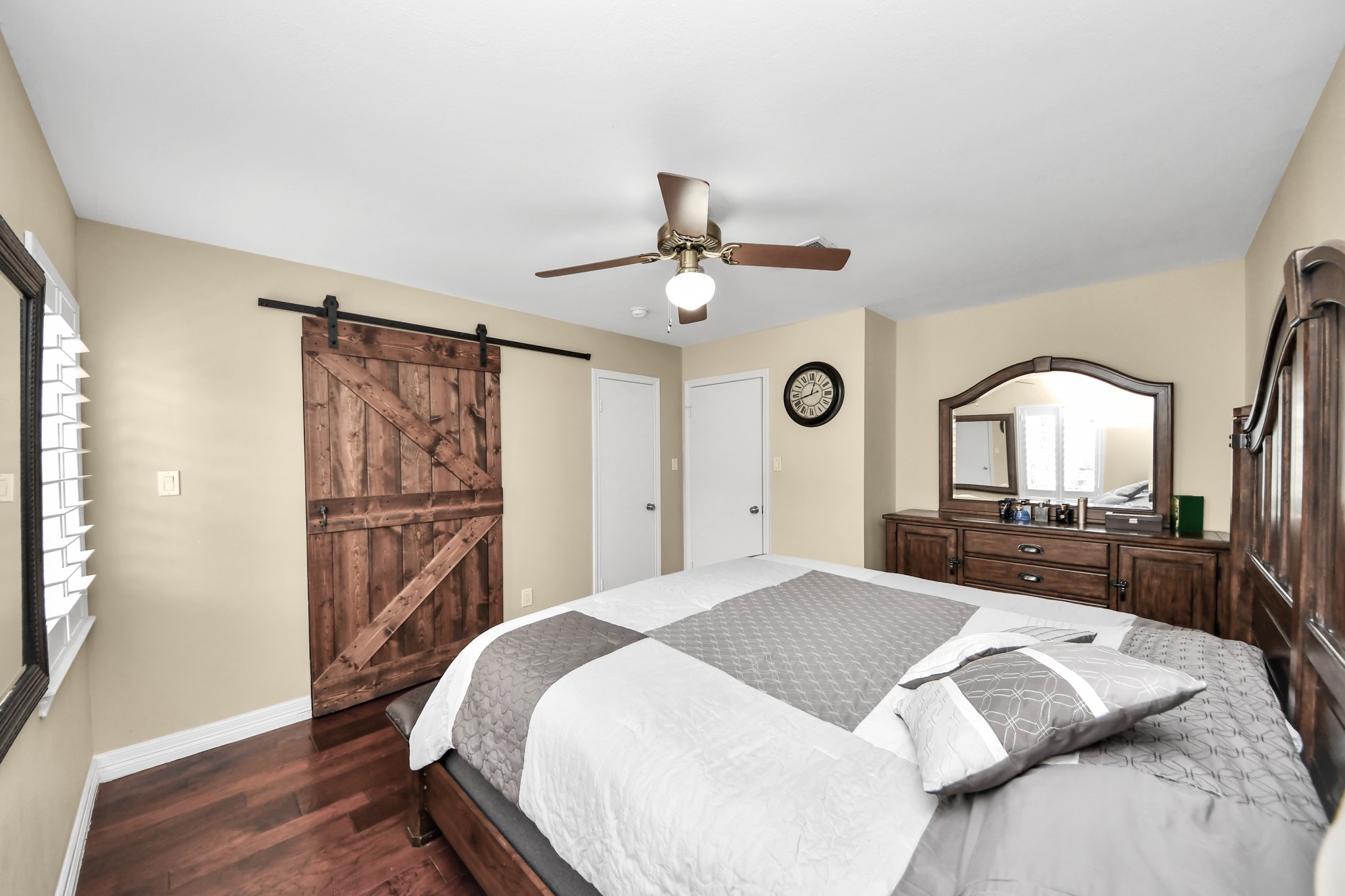 12757 Huntingwick Drive, Unit 142 Houston, TX 77024 - Photo 31 of 36 Primary bedroom with engineered wood floors and a modern sliding barn door that adds character and functionality.