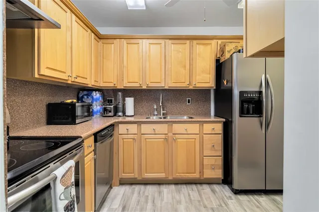 a kitchen with stainless steel appliances granite countertop a refrigerator sink and cabinets