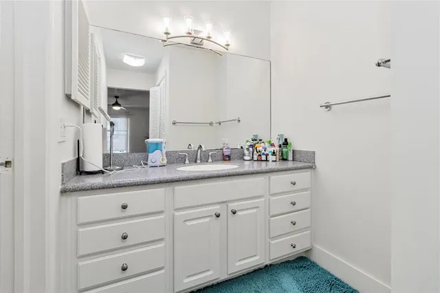 a bathroom with a granite countertop sink double vanity and a mirror