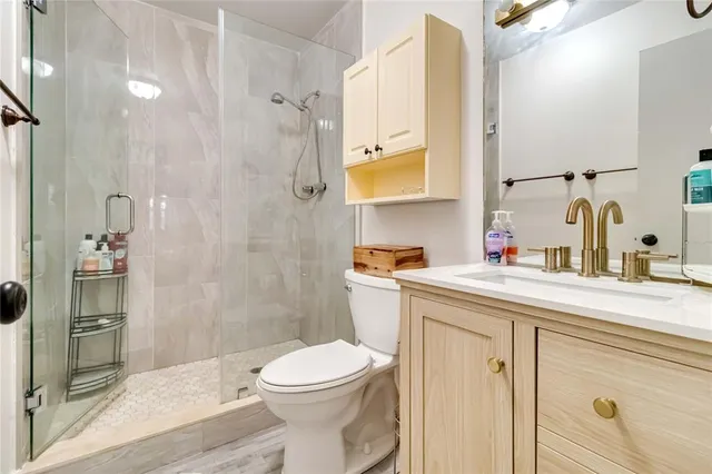 a bathroom with a sink a toilet and shower