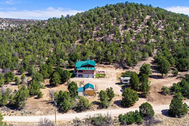 75 Wray Mesa Road La Sal, UT 84530 - Photo 55 of 59 Hillside residence with a green metal roof, a detached auxiliary structure, and a large natural landscape