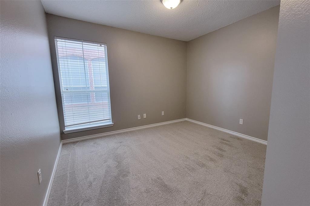1604 Knoll Ridge Circle Corinth, TX 76210 - Photo 31 of 37 Neutral-toned room featuring a large window with horizontal blinds, light-colored carpeting, and white baseboards