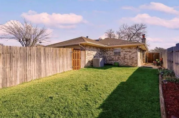 a view of a house with a big yard and large tree