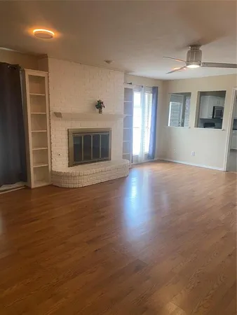 a view of a big room with wooden floor and a kitchen