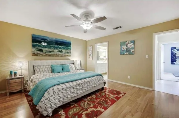 a bedroom with a large bed and a chandelier