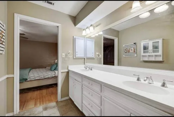 a en suite bathroom with a double vanity sink and mirror