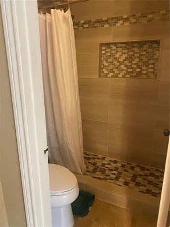 a bathroom with a toilet and a shower
