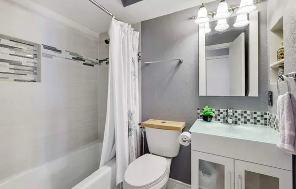 a white toilet sitting next to a bathroom sink