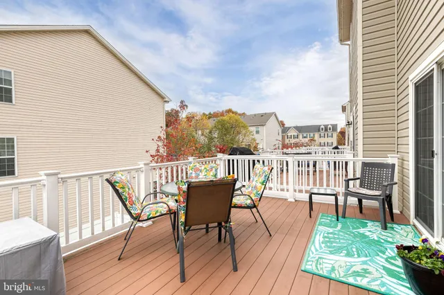 a view of a balcony with wooden floor and outdoor seating
