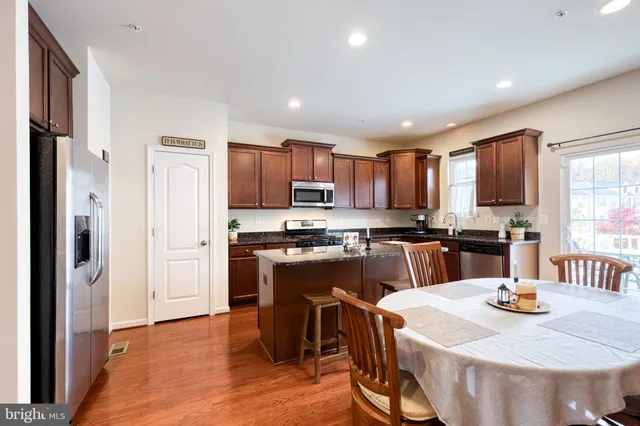 a kitchen with a sink a kitchen island and stainless steel appliances