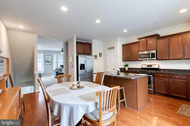 a large kitchen with kitchen island granite countertop a dining table and chairs