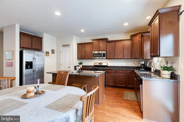 a kitchen with stainless steel appliances granite countertop a sink refrigerator and microwave