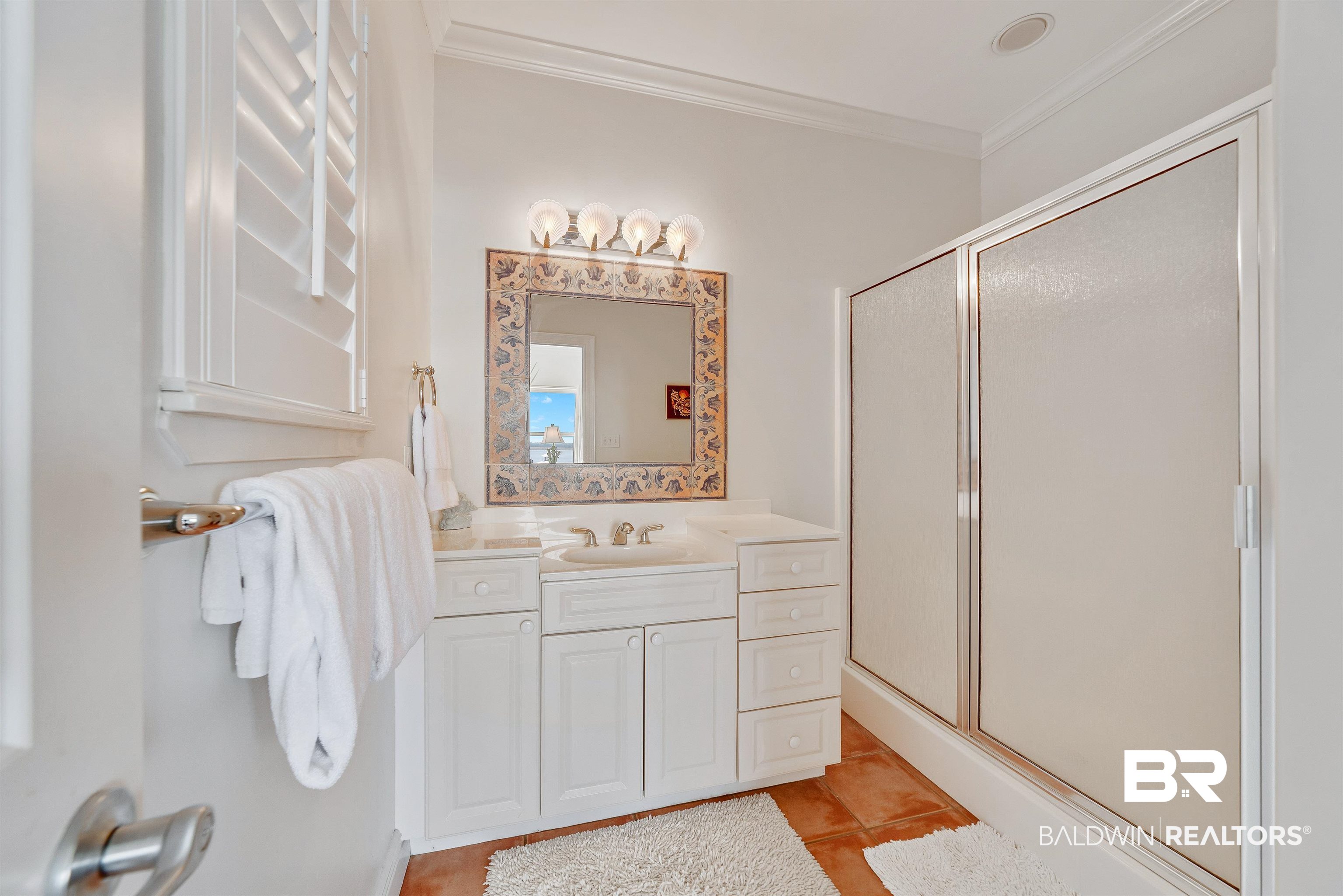 24513 Gulf Bay Road Orange Beach, AL 36561 - Photo 34 of 52 Bathroom featuring ornamental molding, vanity, a shower with door, and tile patterned flooring
