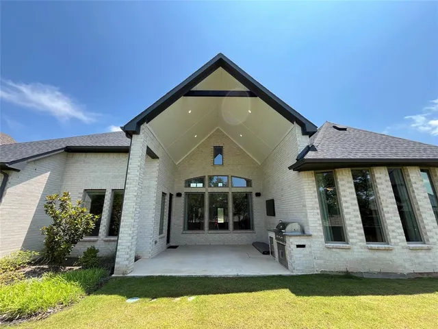 a view of a house with backyard and sitting area