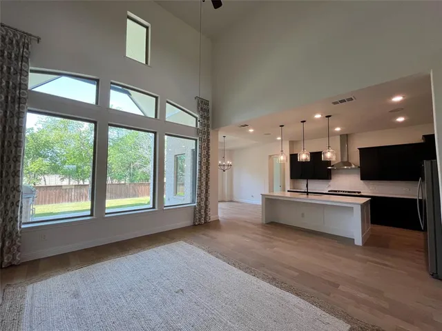 a view of an empty room with kitchen appliances and furniture
