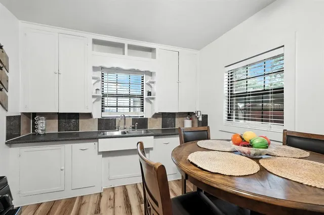 a kitchen with stainless steel appliances granite countertop a sink a stove a dining table and chairs