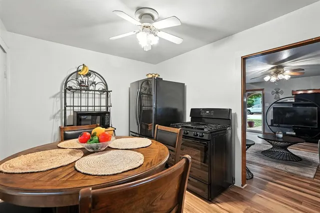 a dining room with furniture a chandelier and wooden floor
