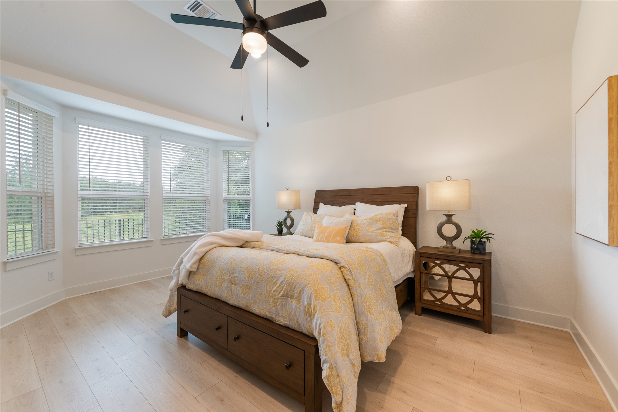 294 Kimble Creek Loop Kyle, TX 78640 - Photo 13 of 40 Generous light streams into this bedroom, featuring vaulted ceilings and light wood flooring.