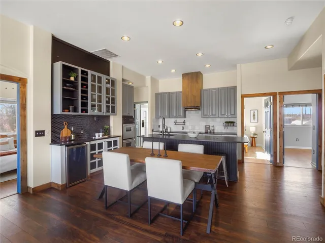 a kitchen with a table chairs refrigerator and cabinets