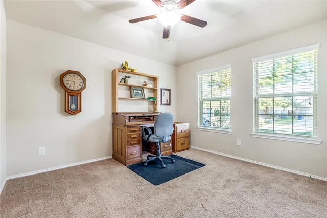 a view of a workspace with furniture and a window