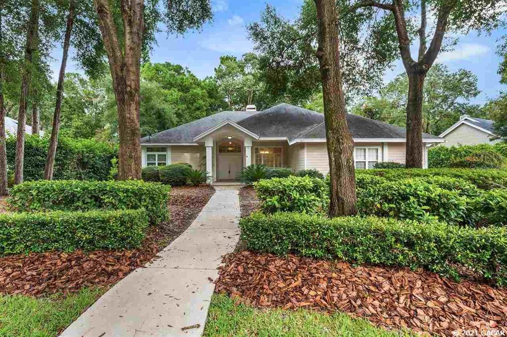 3837 Southwest 93 Terrace Gainesville, FL 32608 - Photo 1 of 1 a front view of a house with a yard and large trees