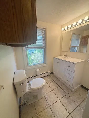 a bathroom with a granite countertop sink toilet a mirror and a vanity