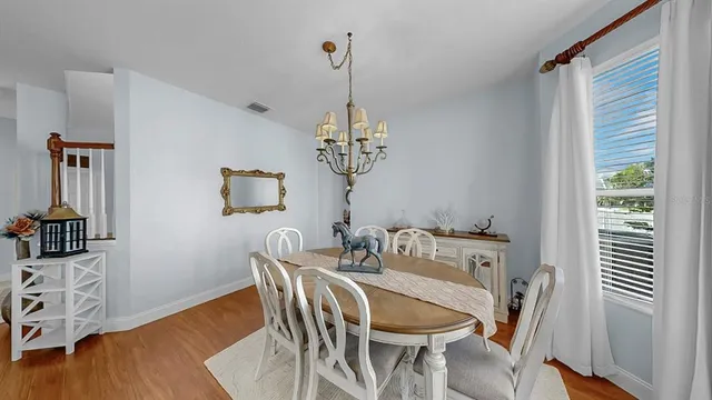 a kitchen with stainless steel appliances granite countertop a stove a sink dishwasher a dining table and chairs with wooden floor