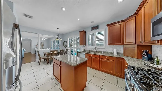 a view of a dining room and livingroom with furniture wooden floor a chandelier
